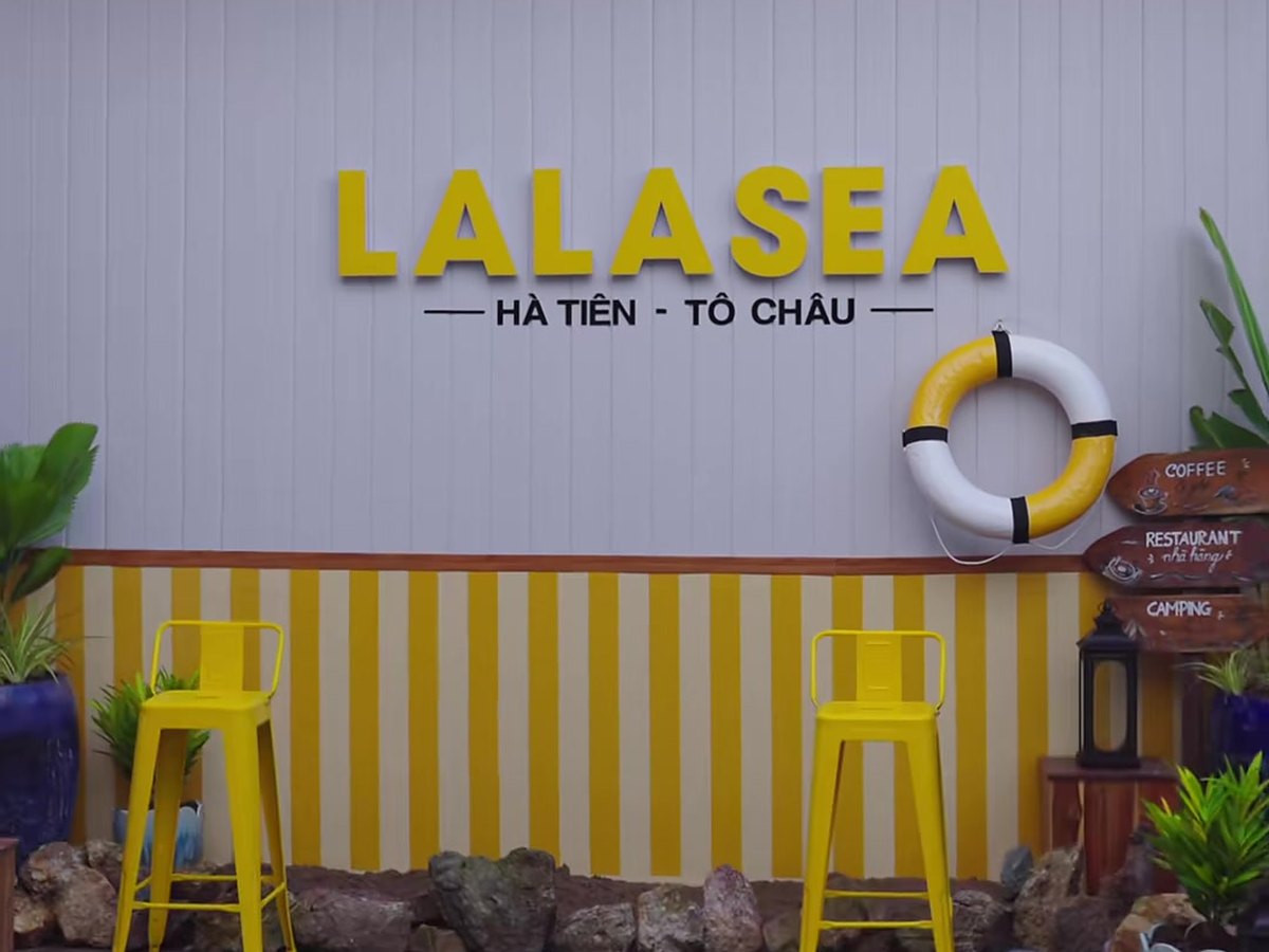 Bảng hiệu LALASEA Hà Tiên – Tô Châu chữ vàng nổi trên tường sọc, kèm hai ghế cao màu vàng