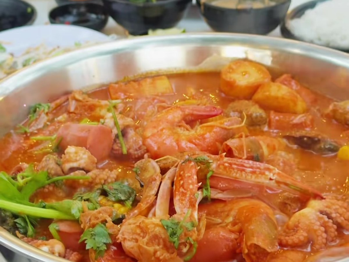 Lẩu hải sản tại Lalasea Bistro Hà Tiên — tôm, cua, bắp và xúc xích trong nước lẩu đỏ, đặt trên bếp